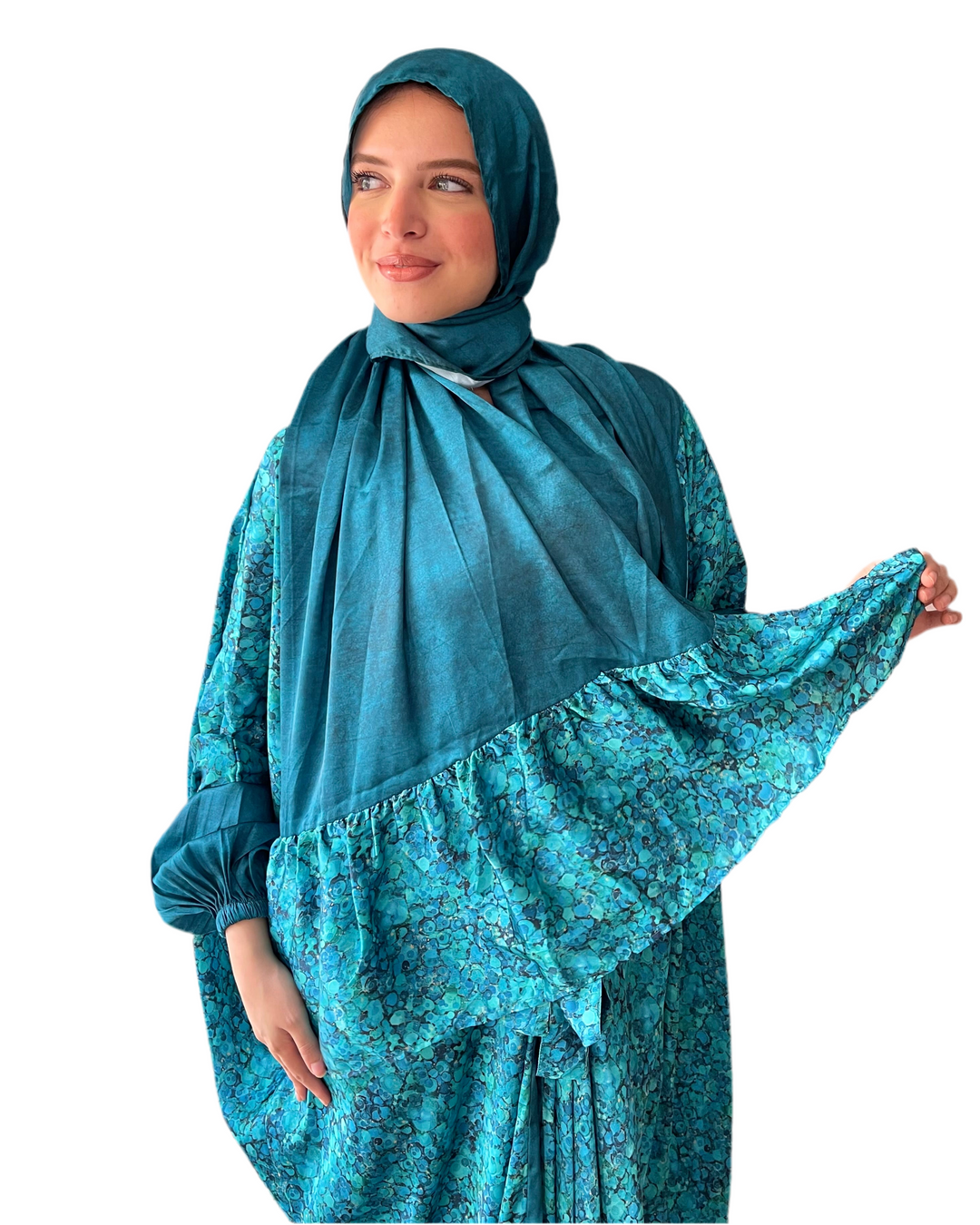 Woman wearing a teal dress with matching hijab on a white background