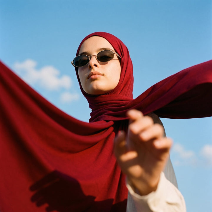 Ruby red instant hijab with sunglasses against a blue sky